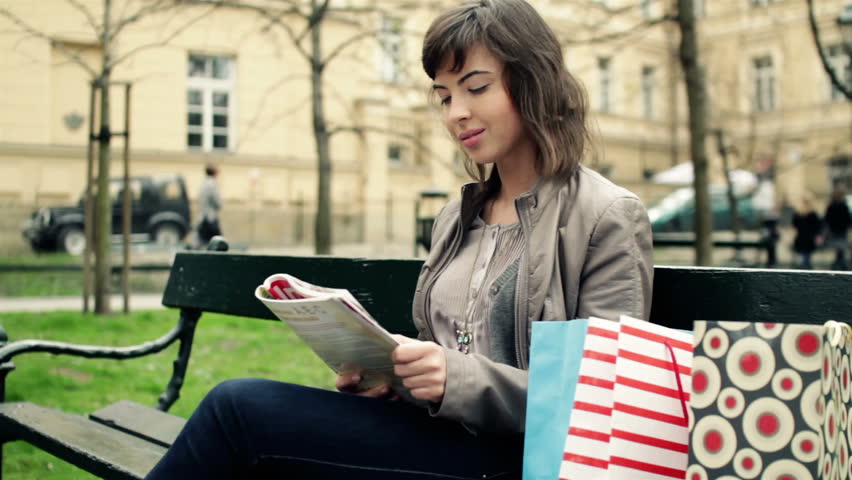 Young woman reading magazine in the park
