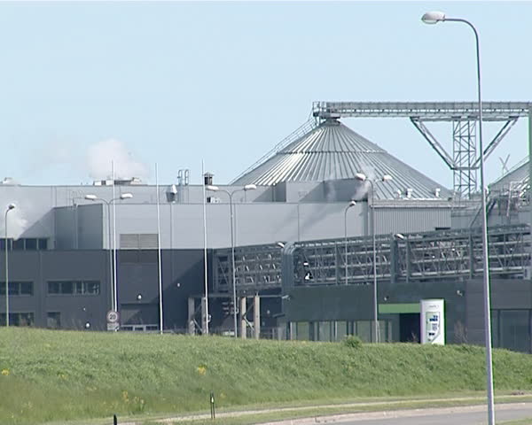 biodiesel and rape oil factory industrial buildings on background of blue sky. vapor smoke evaporate from chimney. organic natural fuel industry