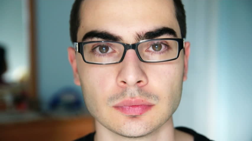 Serious young man at home looking at camera.