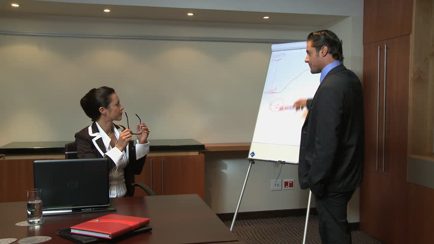 LONG SHOT OF A BUSINESSMAN GIVING A PRESENTATION