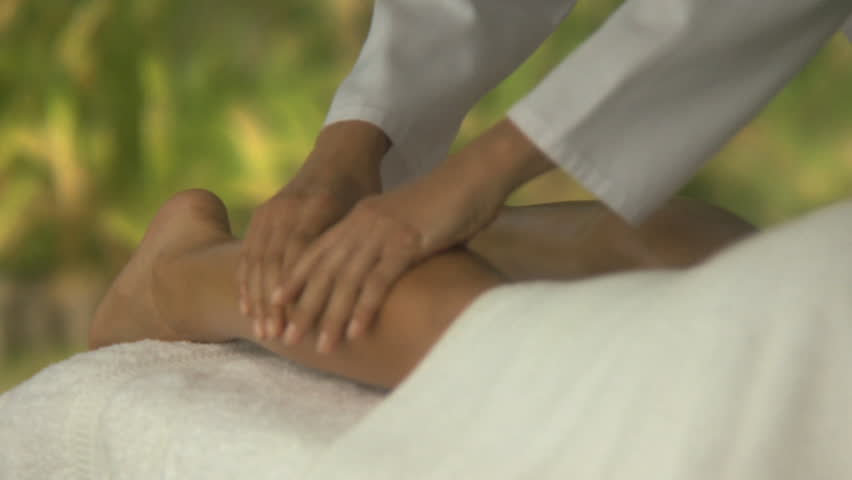 MEDIUM CLOSE UP OF A WOMAN HAVING A LEG MASSAGE
