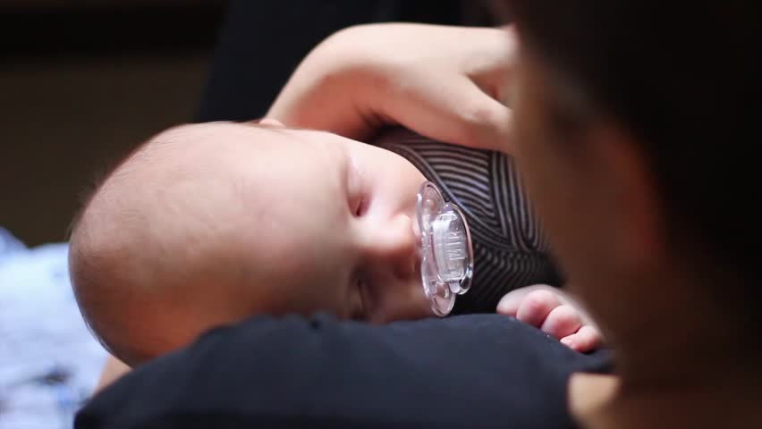 A young mother holding her beautiful newborn baby boy