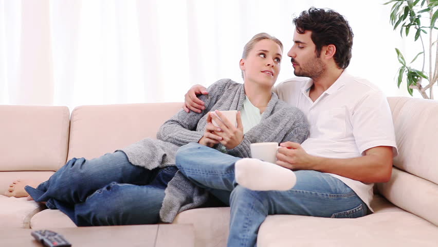 Couple talking to each other while sitting on a couch