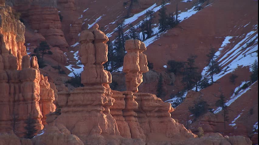 Zoom out from balanced red rocks in winter with light snow on ground