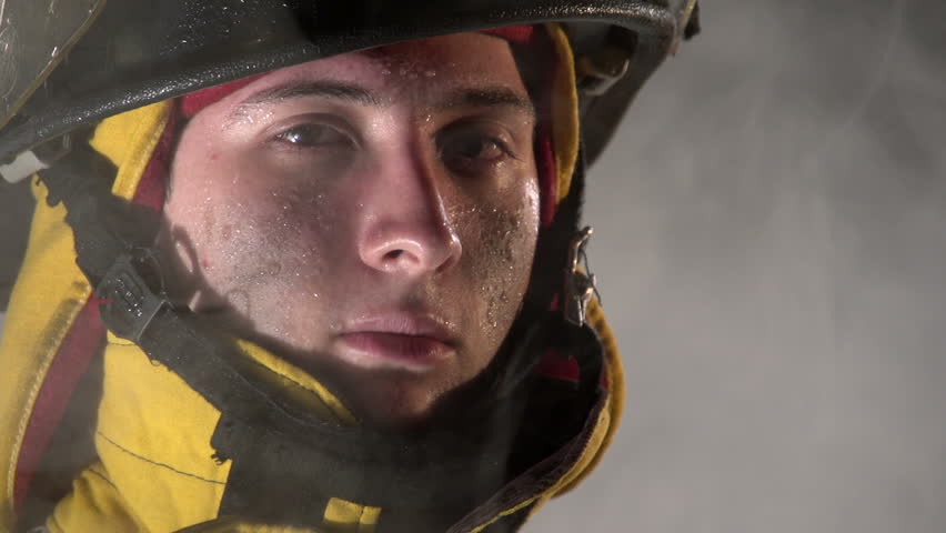 Firefighter looking at camera through smoke, slow motion