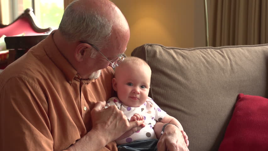 Grandfather on the couch with his baby granddaughter