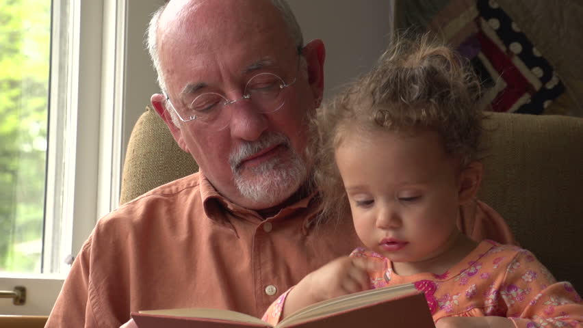Grandfather reading to his granddaughter