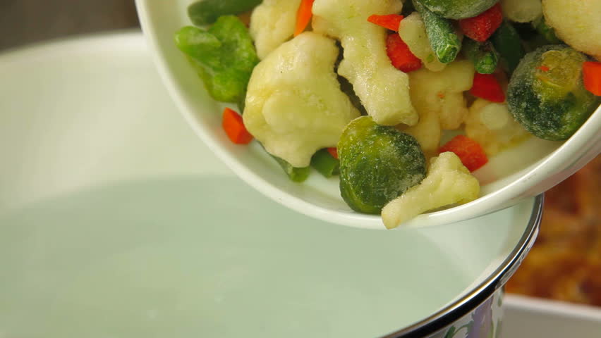 Pouring the vegetables in a pot with boiling water