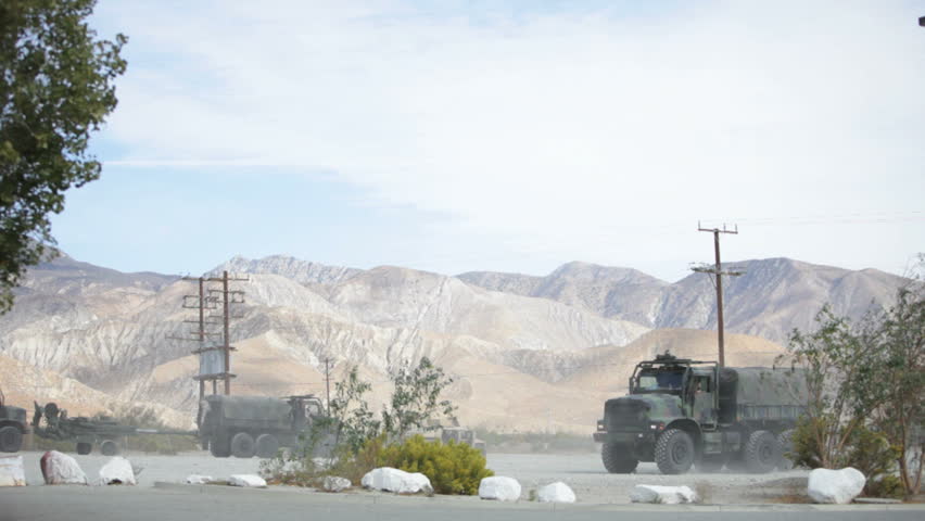 military convoy moving out in desert area