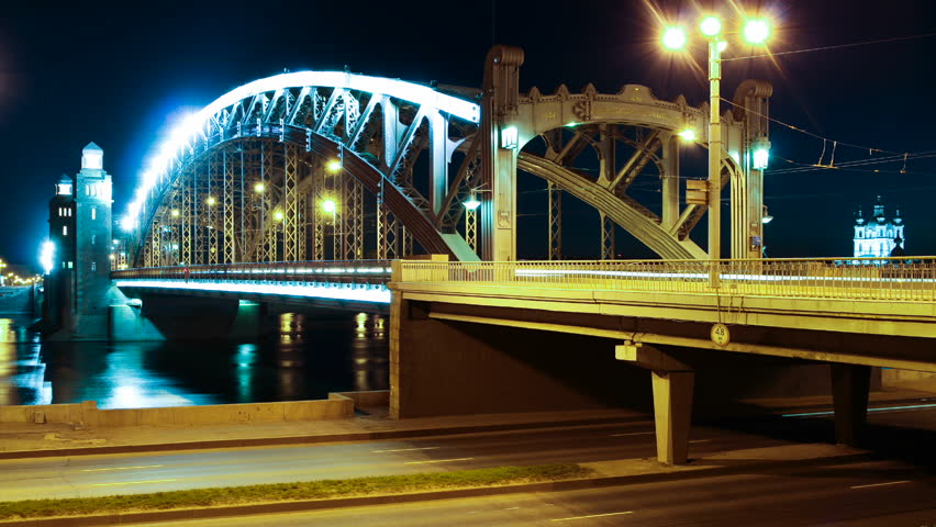 Cars drive through on the bridge and under the bridge the night of the city (St. Petersburg, Russian Federation)