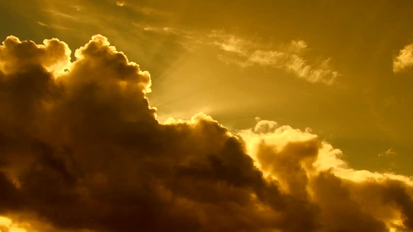 Beautiful cloudscape with large, building clouds and sunset behind shining sun rays and eventually breaking through cloud mass. Full HD 1920 x 1080.