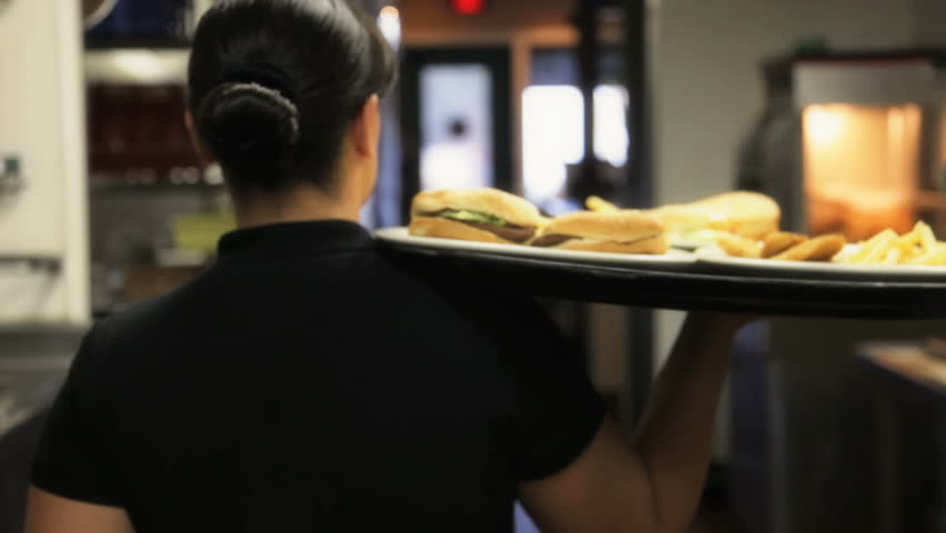 Waitress caring order out to customers