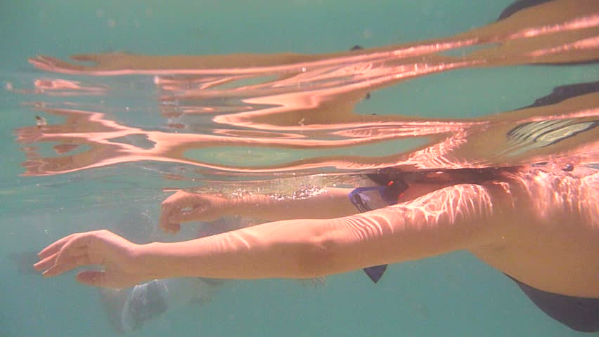 Woman snorkeling past camera off of Chileno Bay in Cabo, Mexico.