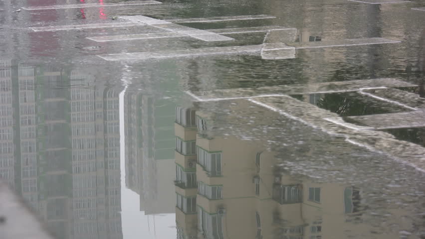 Reflection of a cyclist riding through the rain in Beijing, China