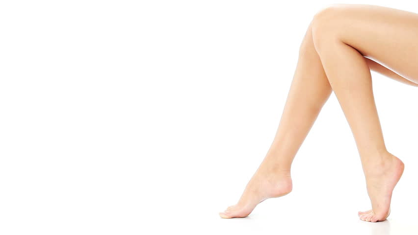 Beautiful female legs isolated over white background. touching leg by hand, beauty and skin care concept.