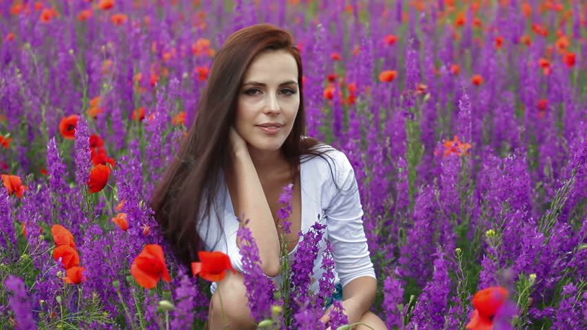 Attractive young woman posing in blossoming field