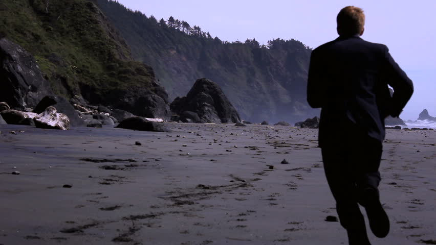 A business man running away from a dog that eventually catches up to him as he twists his ankle and falls