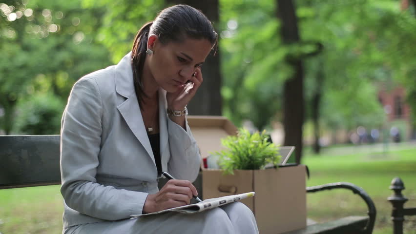 Just fired, unemployed businesswoman looking for job in newspaper
