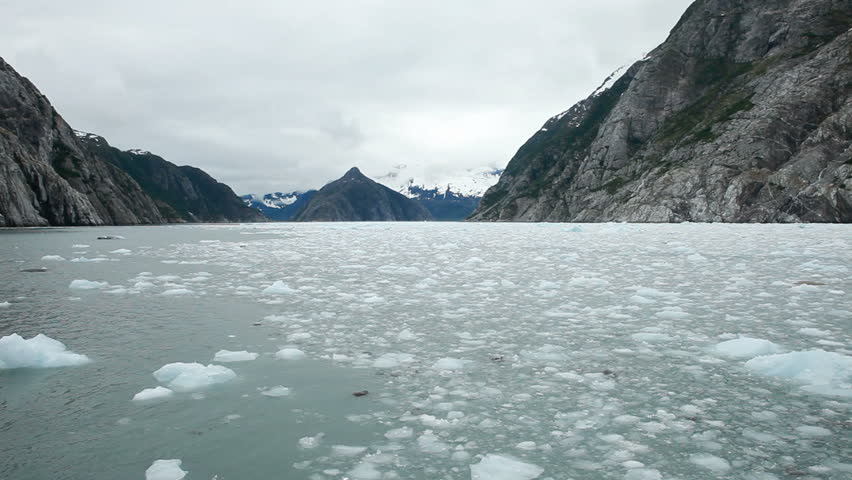 Ice flow melting from Glacier and ocean fjord from boat as it reaches the ocean fjord of  Kenai fjord National Park, Kenai Alaska. Glacial ice and snow. 