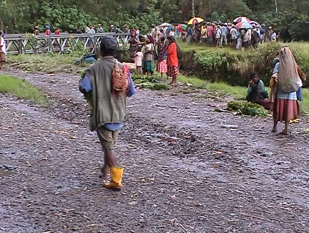 Man in one yellow boot walking on muddy road