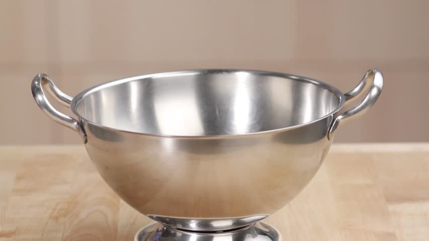 Eggs being cracked into a metal bowl