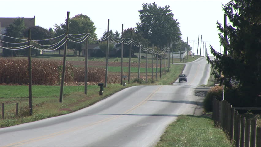 Amish man with bike scooter riding down the road in Lancaster, Pennsylvania