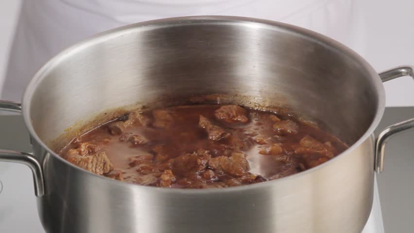 Seasoning beef goulash with ground paprika