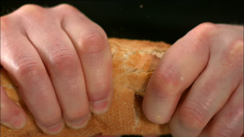 Man tearing baguette in half