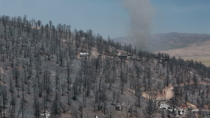 Forest wildfire homes destroyed twister crosses hill. Charred burnt homes and business. Blaze destroyed dozens of homes. Wood Hollow Utah. FEMA Government assistance. Drought with strong summer winds