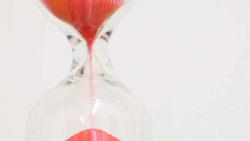 Sand falling in hourglass - passing time concept