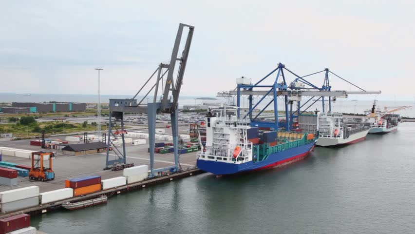 Shipment of cargo in containers to barges by huge cranes and reachstackers