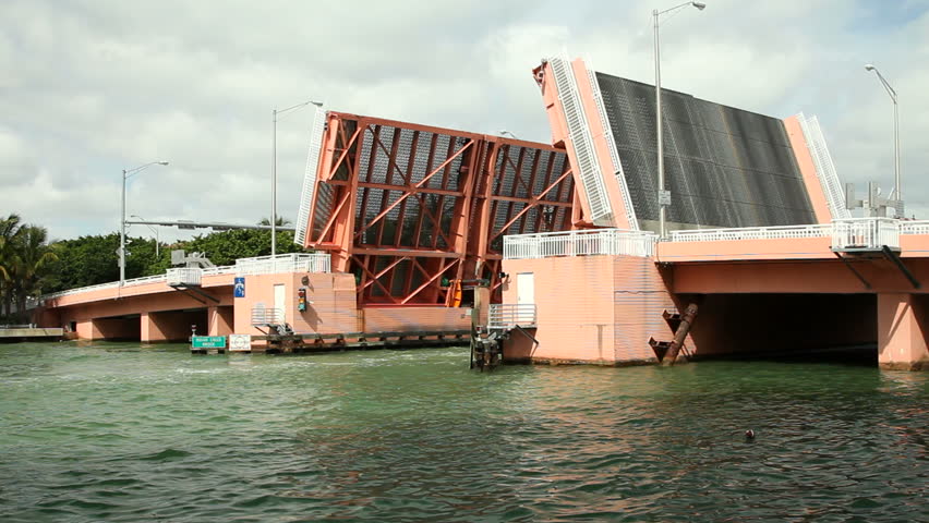 Beautiful luxury nautical vessel crossing under raised Indian Creek Bridge in Miami Beach, Florida