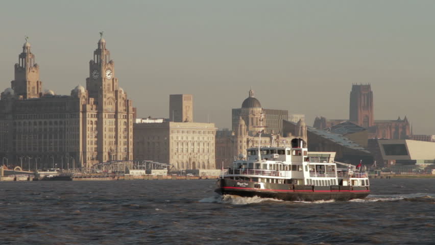LIVERPOOL, MERSEYSIDE - JANUARY 16: The Royal Iris mersey ferry sails past the Liver Buildings, UNESCO Liverpool waterfront on January 16, 2012 in Liverpool, England.