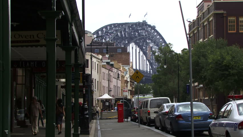 Sydney, Australia - April 2010: People walking in a shopping arcade with the Harbour bridge in the background. Sydney is in the top 21 of the worlds most desired holiday destinations.