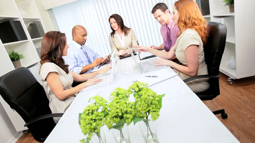 Female Caucasian advertising executive boardroom meeting multi ethnic team