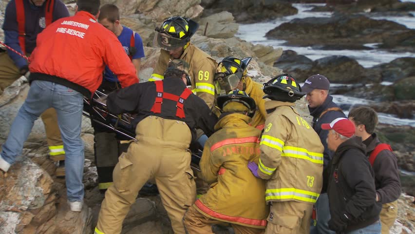 JAMESTOWN, RHODE ISLAND - CIRCA NOVEMBER 2010: Rescue crews carrying stretcher with woman on rocky shore - closeup