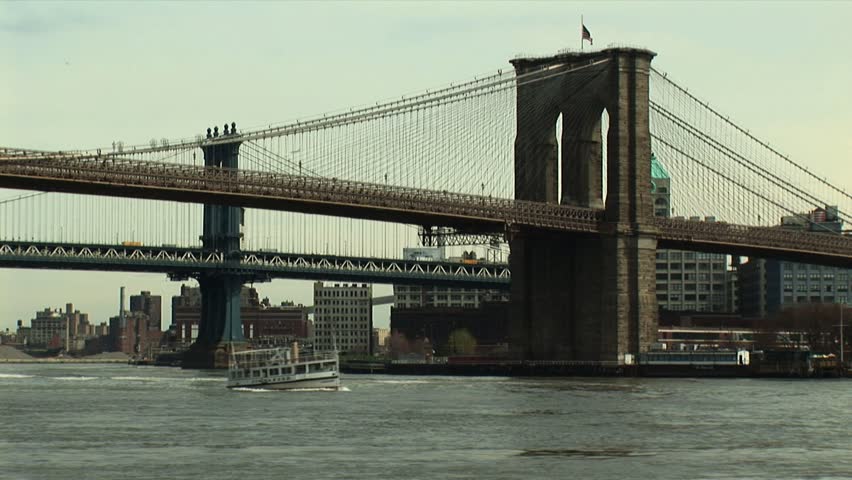 NEW YORK CITY, NY - CIRCA JUNE 2005: Brooklyn Bridge with small boat Commander passing underneath