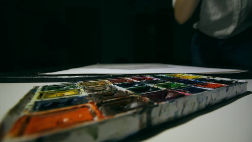Woman artist painting watercolor paints