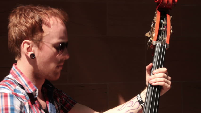 LIVERPOOL, MERSEYSIDE/ENGLAND - MAY 22: Unidentified man busks on a double bass on May 22, 2012 in Liverpool. Liverpool council wants to introduce compulsory permits for street performers.
