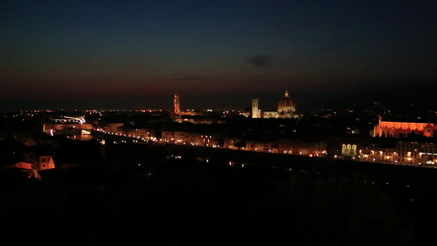 Pan shot of a city lit up at night, Florence, Tuscany, Italy