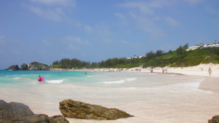 Multiple wide shots of people enjoying the beach on the shore of Horseshoe Bay in Bermuda.