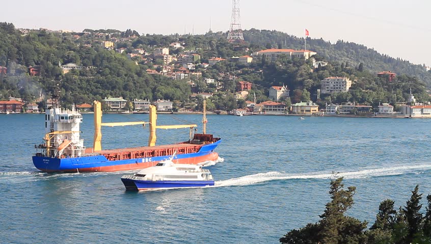 ISTANBUL - JULY 5: Traffic with a cargo ship and a passenger catamaran in Straits Bosporus on July 5, 2012 in Istanbul. Some 50,000 ships pass through the Turkish Straits every year.