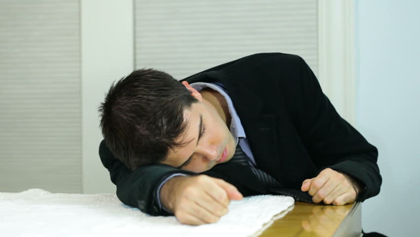Overworked business man who is tired or sleeping on the job.