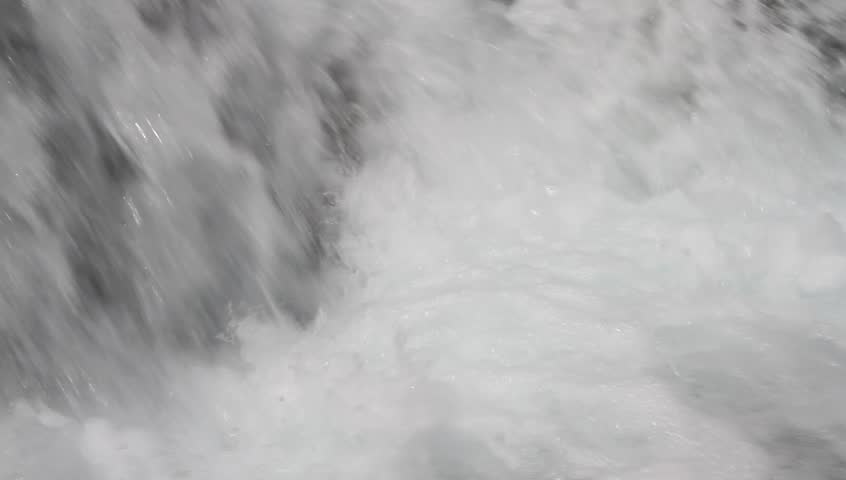 Close up. Water rages in falls