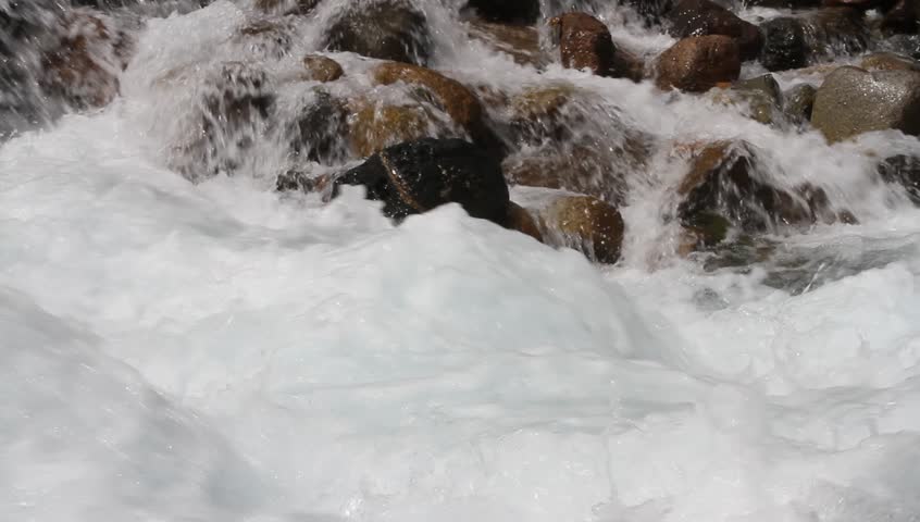 Water promptly flows on stones in a mountain stream