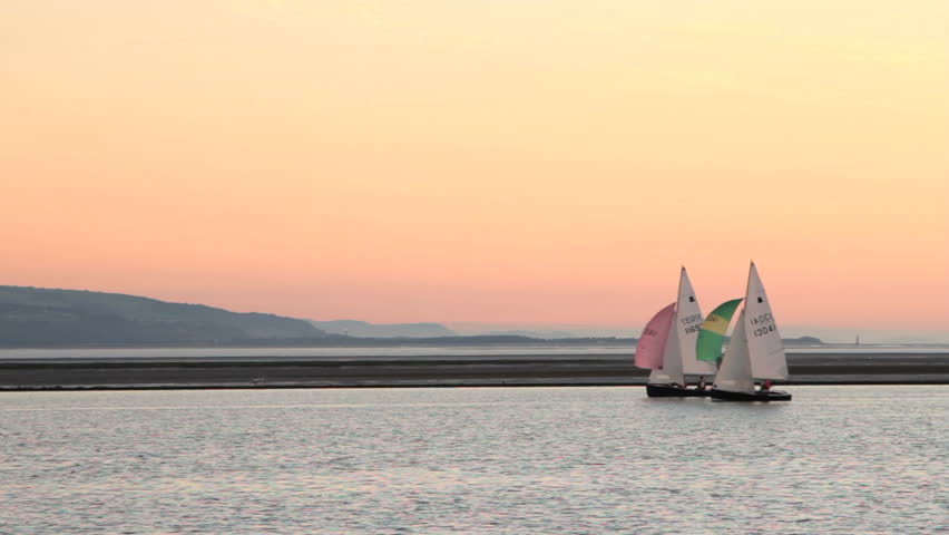 WEST KIRBY, WIRRAL/ENGLAND - AUGUST 9: Two sailing boats with spinnakers sail at sunset on August 9, 2012 in West Kirby. The Marine Lake is a man made coastal lake fed by the sea at high tide.  