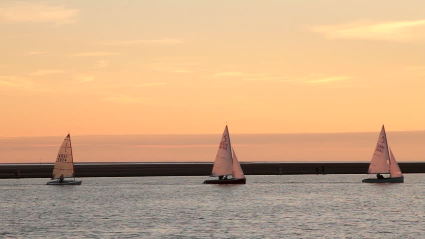 WEST KIRBY, WIRRAL/ENGLAND - AUGUST 9: Sailing boats gently sail on lake at sunset on August 9, 2012 in West Kirby. The Marine Lake is a man made coastal lake fed by the sea at high tide.  