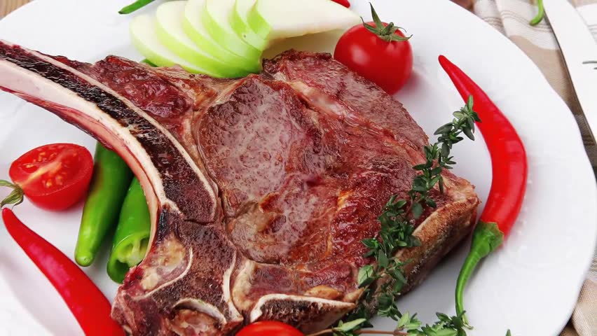 savory : grilled spare rib on green dish with thyme pepper and tomato isolated over white background