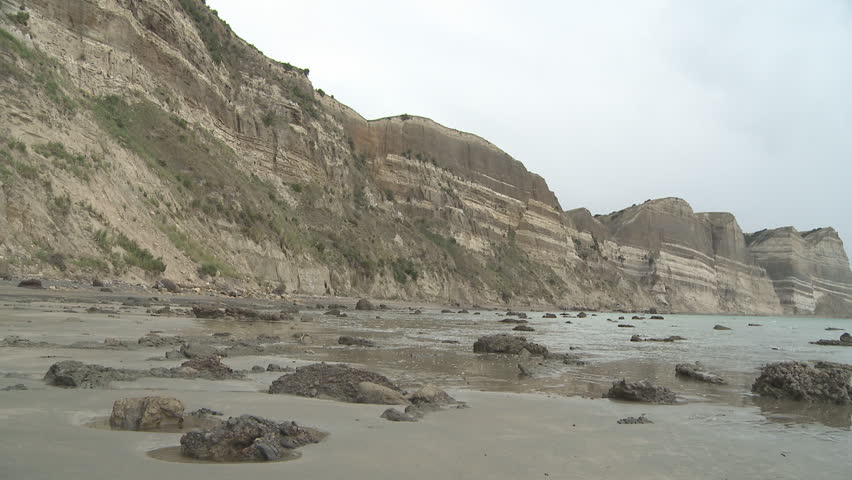 large, eroding cliffs show sedimentary layers from down over the ages.