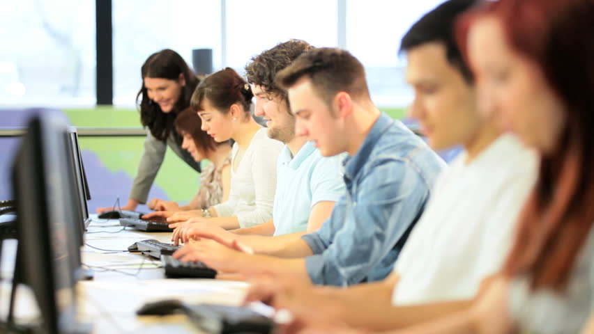 Young male and female diverse classmates follow instructions Caucasian lecturer in IT college class
